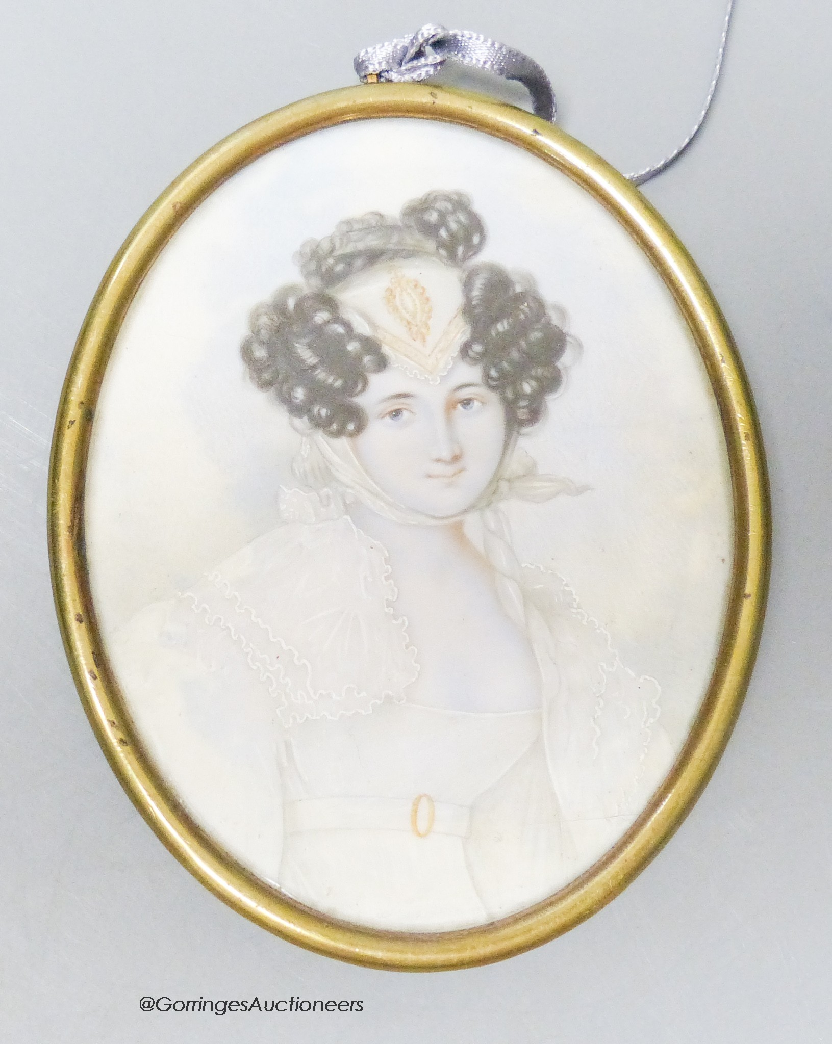 A 19th century portrait miniature, study of a young woman, her hair in ringlets, wearing a lace headdress and white dress